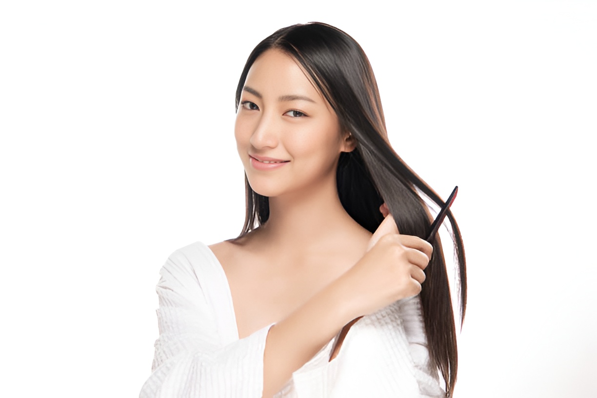 smiling woman combing her black, shiny hair